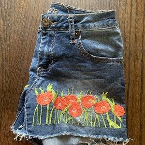 Girl's denim shorts with frayed ends and floral detailing